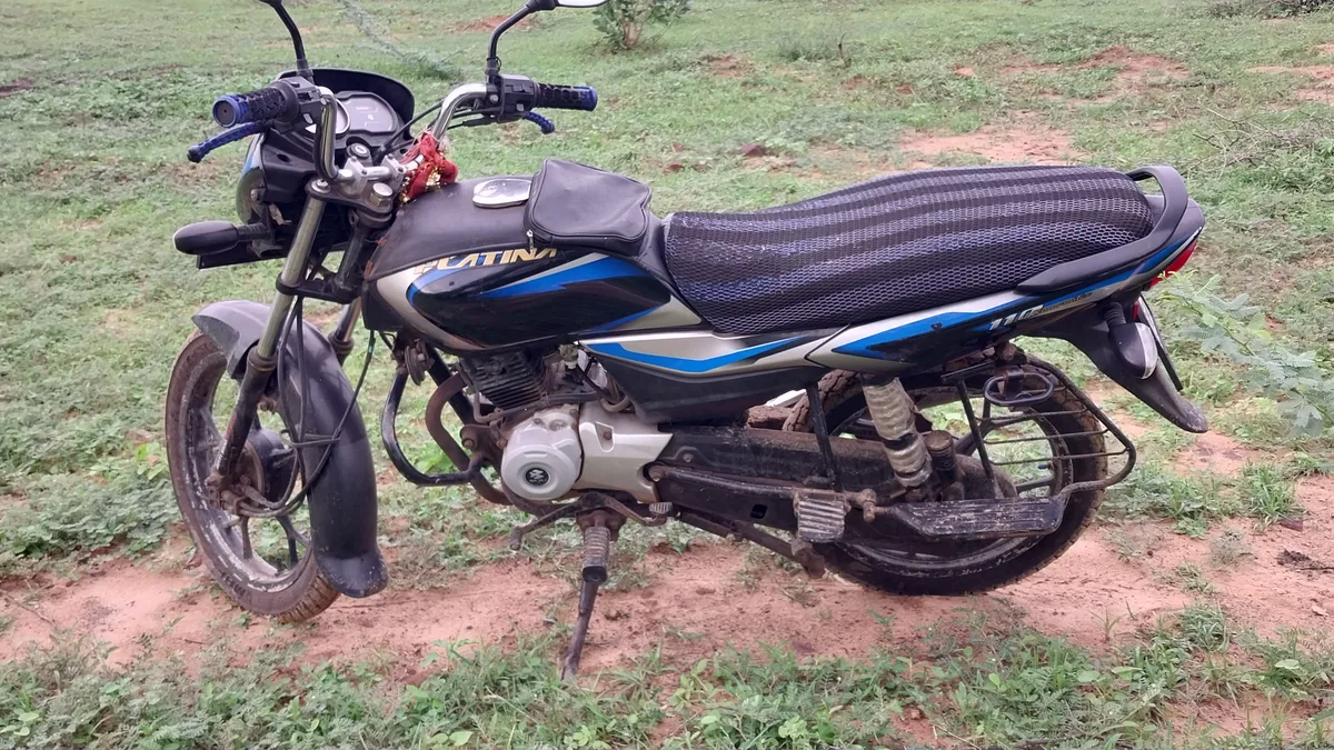 सड़क किनारे खड़ी Bajaj Platina बाइक